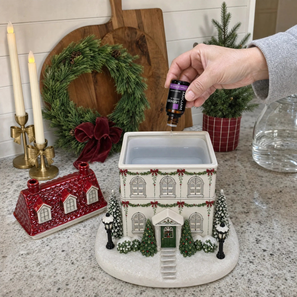 Removable rooftop reveals the Mistletoe Lane diffuser reservoir with essential oil being added